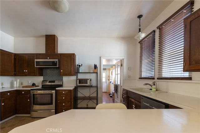 320 W 21st St, Merced, CA 95340 - kitchen featuring stainless steel appliances, light countertops, pendant lighting, dark brown cabinets, and tasteful backsplash
