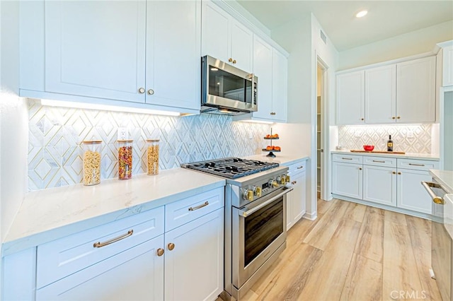 27505 Illumination Ct, Valencia, CA 91381 - kitchen featuring stainless steel appliances, light wood-style floors, white cabinetry, tasteful backsplash, and recessed lighting