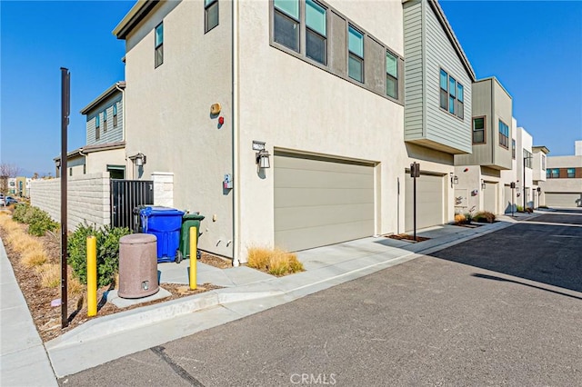 27505 Illumination Ct, Valencia, CA 91381 - view of side of home with an attached garage, a residential view, stucco siding, and driveway
