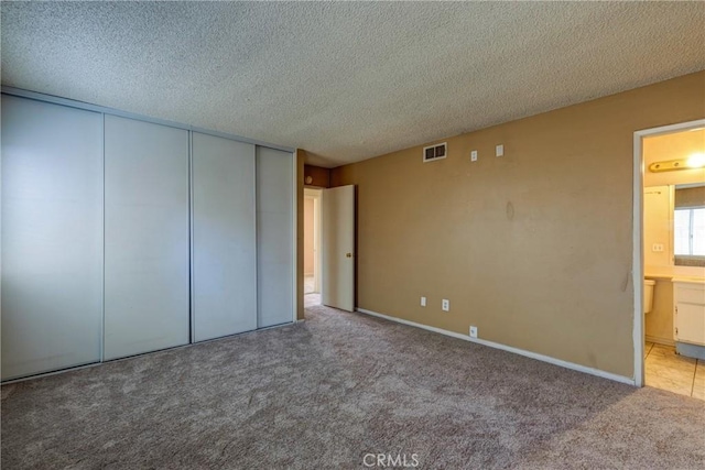 5943 Sky Meadow St, Jurupa Valley, CA 92509 - unfurnished bedroom with carpet floors, a textured ceiling, ensuite bath, and a closet