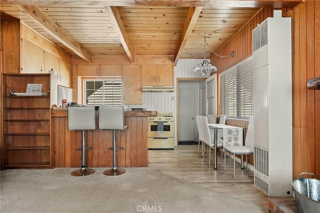 33712 Green Valley Lake Rd, Green Valley Lake, CA 92341 - kitchen featuring white stove, a heating unit, under cabinet range hood, wooden walls, and a wooden ceiling with exposed beams