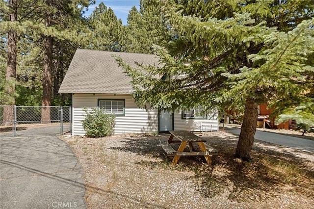33712 Green Valley Lake Rd, Green Valley Lake, CA 92341 - view of property hidden behind natural elements featuring a gate and a shingled roof