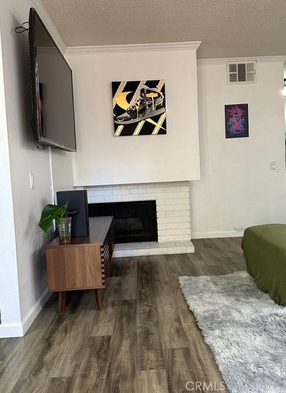 2200 Woodside Ln Unit 2, Sacramento, CA 95825 - living area with wood finished floors, ornamental molding, a textured ceiling, and a brick fireplace