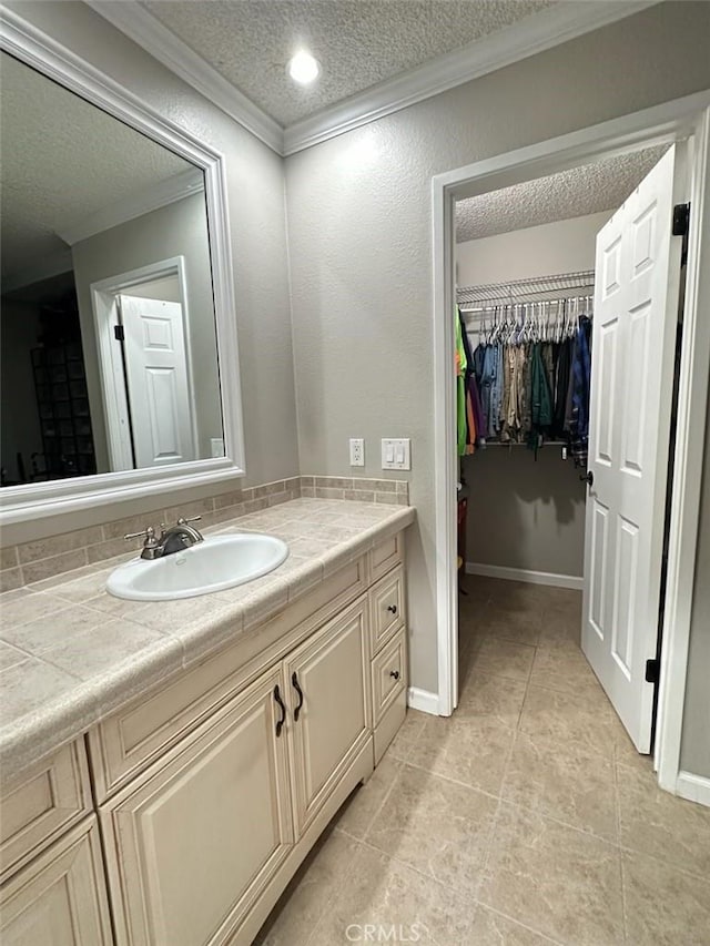 2200 Woodside Ln Unit 2, Sacramento, CA 95825 - bathroom featuring a textured ceiling, ornamental molding, vanity, a walk in closet, and tile patterned flooring
