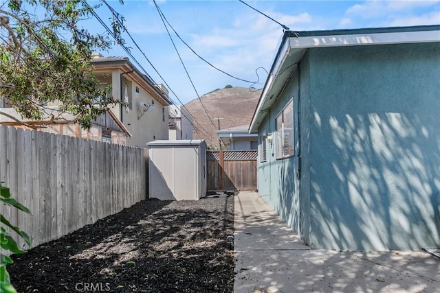 244 Santa Fe Ave, Pismo Beach, CA 93449 - view of side of property featuring a fenced backyard, stucco siding, a storage shed, and a mountain view