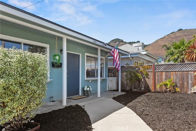 244 Santa Fe Ave, Pismo Beach, CA 93449 - view of exterior entry featuring stucco siding, a porch, and a mountain view