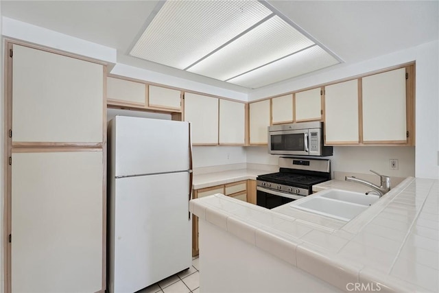 4240 Lost Hills Rd Unit 2205, Calabasas, CA 91301 - kitchen with stainless steel appliances, tile countertops, a peninsula, and light tile patterned floors