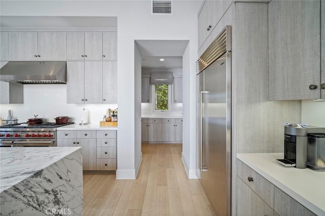 16 Seawatch, Newport Coast, CA 92657 - kitchen with high quality appliances, extractor fan, light wood-style flooring, recessed lighting, and light stone countertops