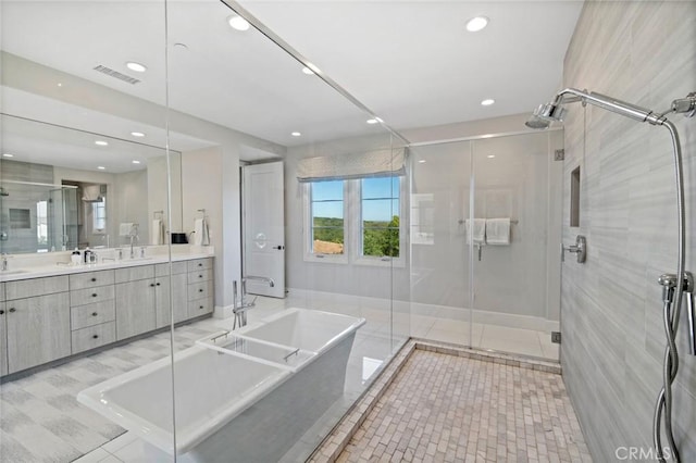 16 Seawatch, Newport Coast, CA 92657 - bathroom with a freestanding bath, double vanity, a shower stall, recessed lighting, and tile patterned flooring