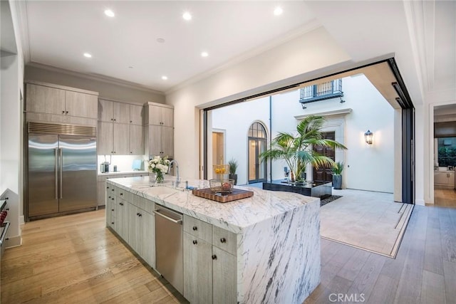 16 Seawatch, Newport Coast, CA 92657 - kitchen featuring stainless steel appliances, a kitchen island with sink, light stone countertops, light wood finished floors, and recessed lighting