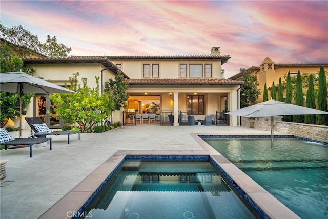 16 Seawatch, Newport Coast, CA 92657 - rear view of property with stucco siding, a patio, an outdoor pool, a chimney, and an in-ground hot tub