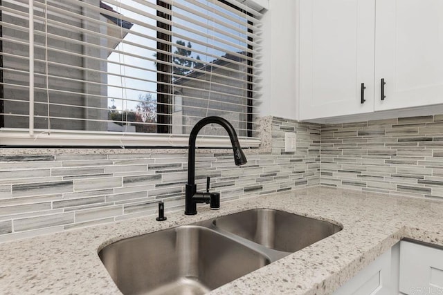 7528 Jerez Ct Unit 6, Carlsbad, CA 92009 - kitchen view of decorative backsplash, white cabinetry, and light stone counters