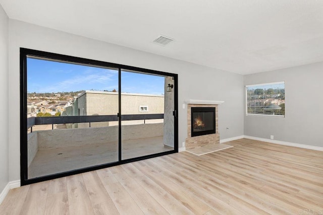 7528 Jerez Ct Unit 6, Carlsbad, CA 92009 - unfurnished living room featuring wood finished floors and a tiled fireplace