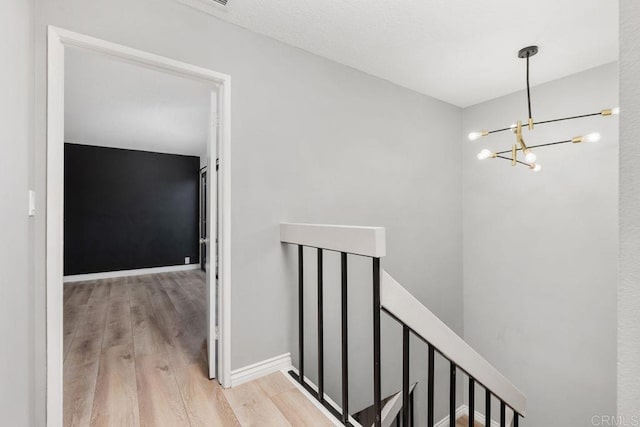 7528 Jerez Ct Unit 6, Carlsbad, CA 92009 - hallway featuring an upstairs landing, wood finished floors, and a chandelier