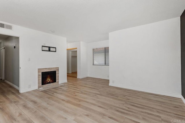 7528 Jerez Ct Unit 6, Carlsbad, CA 92009 - unfurnished living room with light wood-style floors and a fireplace with flush hearth