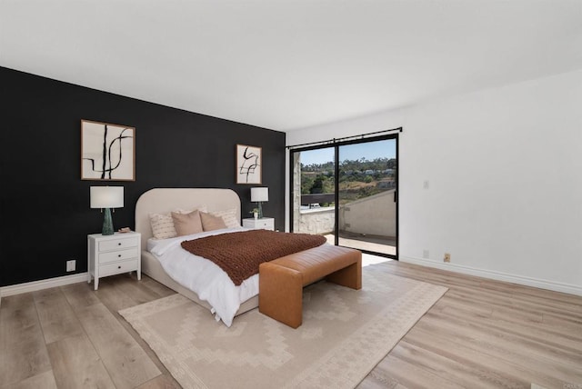 7528 Jerez Ct Unit 6, Carlsbad, CA 92009 - bedroom featuring access to outside, light wood-style floors, and an accent wall