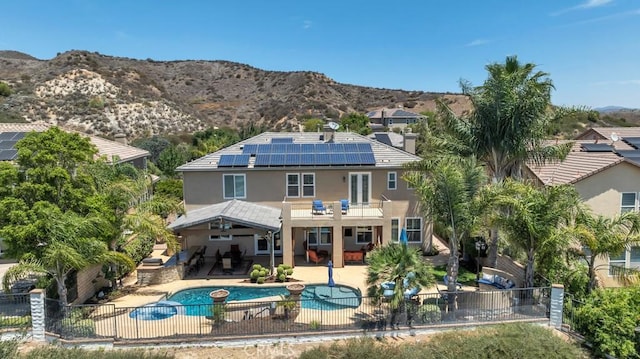 24234 Reyes Adobe Way, Valencia, CA 91354 - rear view of property with a balcony, a fenced backyard, roof mounted solar panels, and a patio