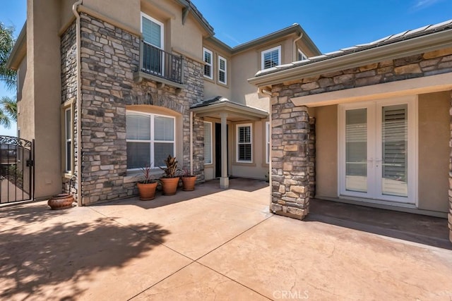 24234 Reyes Adobe Way, Valencia, CA 91354 - back of property with stone siding, french doors, stucco siding, and a balcony