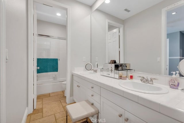 24234 Reyes Adobe Way, Valencia, CA 91354 - bathroom with stone tile flooring, double vanity, recessed lighting, and shower / bath combination with glass door