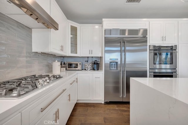 24234 Reyes Adobe Way, Valencia, CA 91354 - kitchen featuring stainless steel appliances, range hood, backsplash, light countertops, and glass insert cabinets