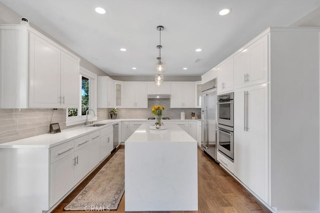 24234 Reyes Adobe Way, Valencia, CA 91354 - kitchen with stainless steel appliances, a center island, decorative backsplash, light countertops, and recessed lighting