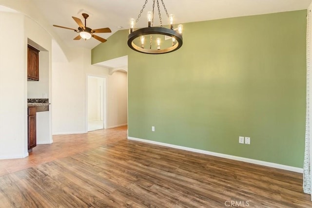 14296 Bieri St, Mojave, CA 93501 - unfurnished room featuring arched walkways, a chandelier, wood finished floors, a ceiling fan, and vaulted ceiling