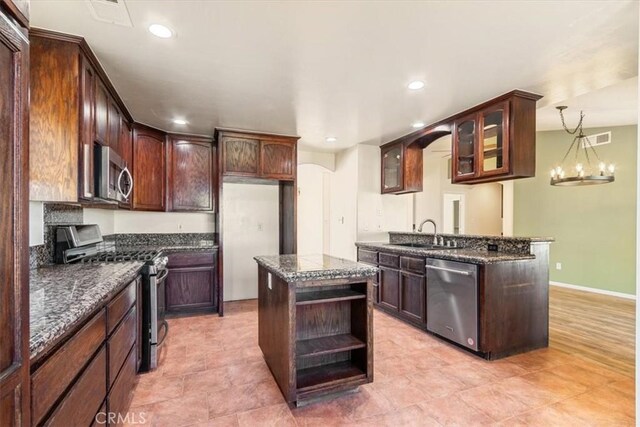 14296 Bieri St, Mojave, CA 93501 - kitchen with appliances with stainless steel finishes, open shelves, recessed lighting, glass insert cabinets, and dark stone counters