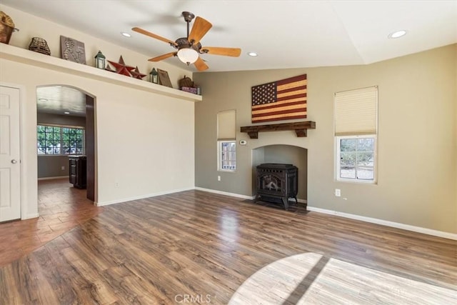 14296 Bieri St, Mojave, CA 93501 - unfurnished living room featuring a wood stove, arched walkways, a ceiling fan, recessed lighting, and wood finished floors