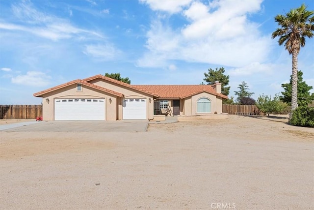 14296 Bieri St, Mojave, CA 93501 - view of front of property featuring a garage, driveway, stucco siding, and a chimney