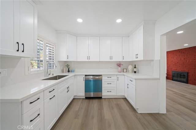 3704 Lorado Way, View Park, CA 90043 - kitchen with dishwasher, light wood-style flooring, light countertops, white cabinetry, and a glass covered fireplace
