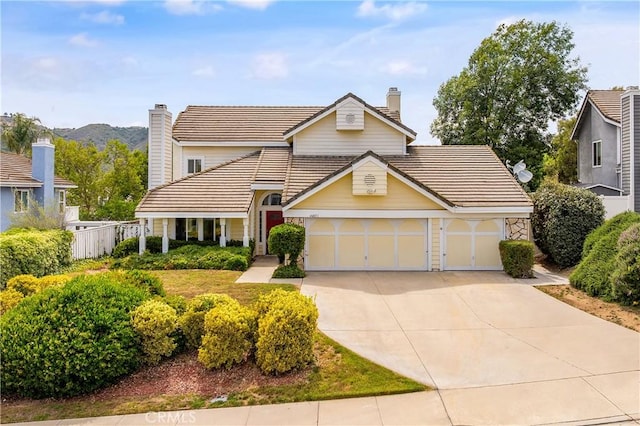 44051 Sheldon Ct, Temecula, CA 92592 - traditional-style home with a tile roof, a chimney, concrete driveway, and an attached garage