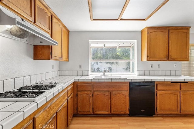 44051 Sheldon Ct, Temecula, CA 92592 - kitchen with under cabinet range hood, dishwasher, white gas cooktop, tile counters, and light wood-type flooring