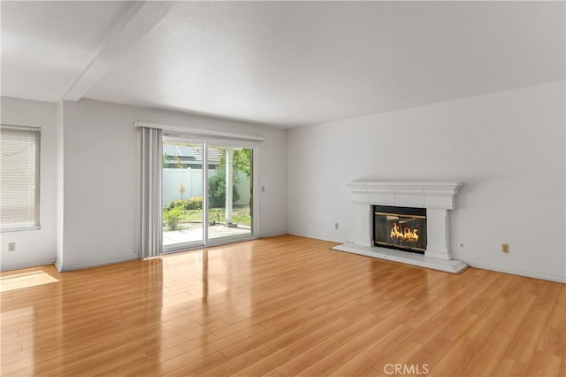 44051 Sheldon Ct, Temecula, CA 92592 - unfurnished living room featuring light wood-type flooring and a glass covered fireplace