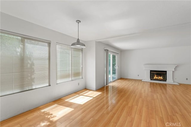 44051 Sheldon Ct, Temecula, CA 92592 - unfurnished living room with light wood-style flooring and a glass covered fireplace