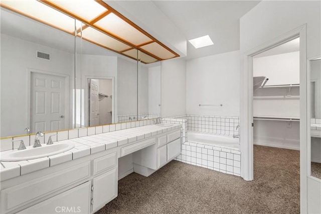 44051 Sheldon Ct, Temecula, CA 92592 - bathroom featuring a skylight, double vanity, a bath, and a spacious closet