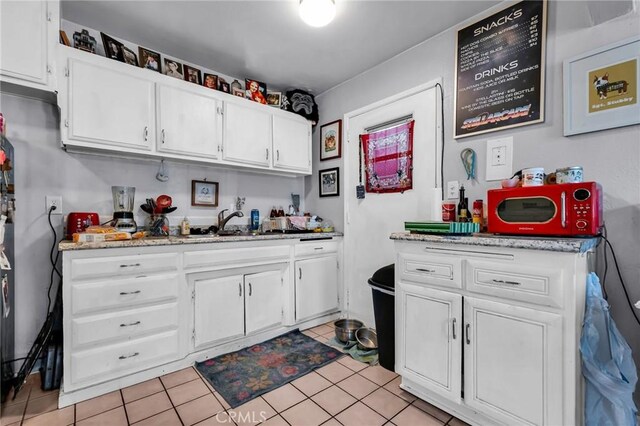 2660 Newell St, County Los Angeles, CA 90039 - kitchen featuring white cabinets, light tile patterned floors, and light stone countertops