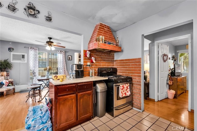 2660 Newell St, County Los Angeles, CA 90039 - kitchen featuring stainless steel range with gas stovetop, light countertops, light wood-type flooring, a ceiling fan, and a peninsula
