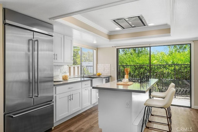 30326 Via Reata, Laguna Niguel, CA 92677 - kitchen with built in refrigerator, a raised ceiling, ornamental molding, dark wood-style floors, and white cabinets