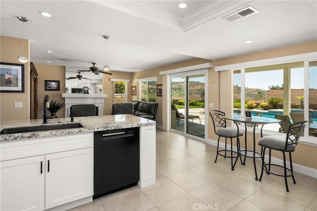 24330 Via Arriba Linda, Yorba Linda, CA 92887 - kitchen with black dishwasher, a ceiling fan, a brick fireplace, light stone countertops, and white cabinetry