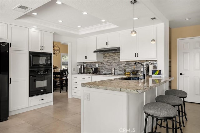 24330 Via Arriba Linda, Yorba Linda, CA 92887 - kitchen featuring black appliances, under cabinet range hood, a peninsula, a breakfast bar, and decorative backsplash