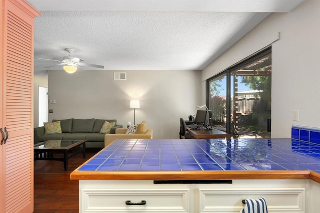 468 Las Brisas Dr, Escondido, CA 92027 - kitchen with tile countertops, dark wood-type flooring, a textured ceiling, ceiling fan, and white cabinets