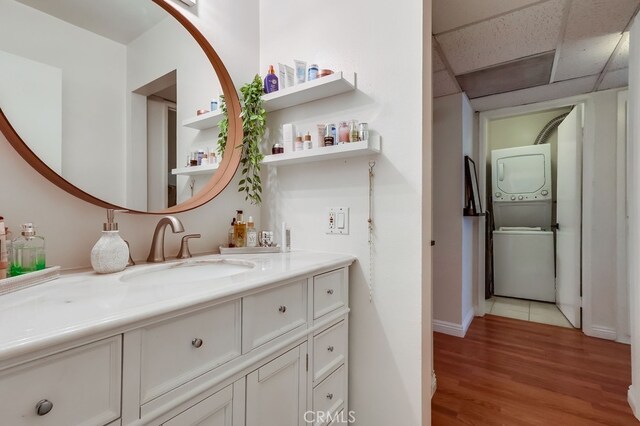 18350 Hatteras St Unit 263, Tarzana, CA 91356 - bathroom featuring stacked washer and clothes dryer, wood finished floors, vanity, and a paneled ceiling