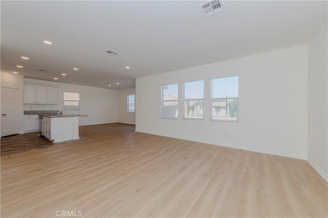 24679 Acadia Dr, Corona, CA 92883 - unfurnished living room with light wood-type flooring and recessed lighting