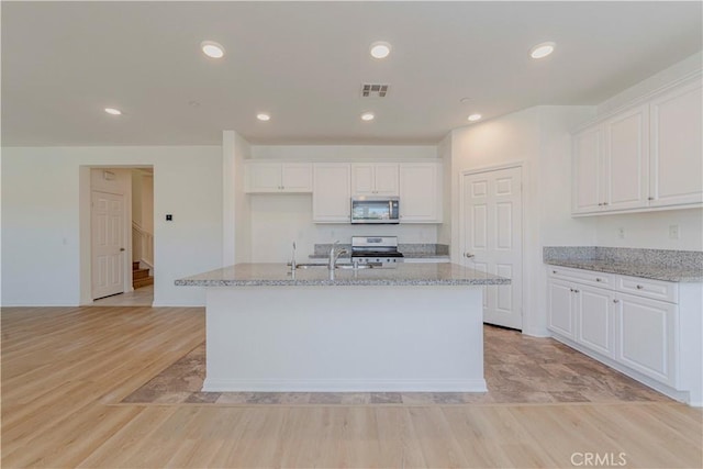 24679 Acadia Dr, Corona, CA 92883 - kitchen with stainless steel appliances, white cabinets, light stone countertops, and recessed lighting