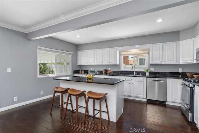 5337 Canehill Ave, Lakewood, CA 90713 - kitchen featuring stainless steel appliances, white cabinetry, dark countertops, a breakfast bar area, and recessed lighting