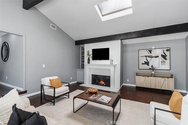 5337 Canehill Ave, Lakewood, CA 90713 - living area with wood finished floors, a warm lit fireplace, and a skylight
