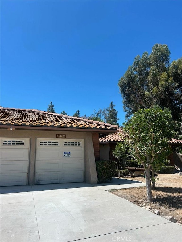 23774 Burton St, West Hills, CA 91304 - view of front of property featuring concrete driveway, a tile roof, and stucco siding
