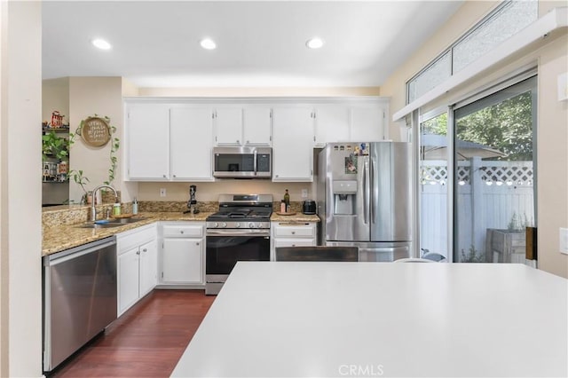28305 Paseo El Siena Unit 10, Laguna Niguel, CA 92677 - kitchen with appliances with stainless steel finishes, white cabinetry, dark wood-type flooring, recessed lighting, and light stone countertops