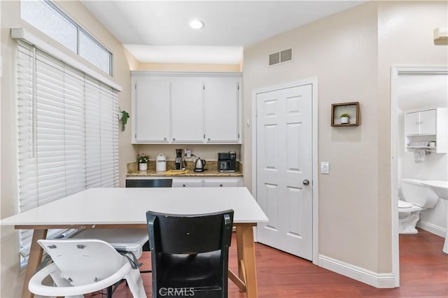 28305 Paseo El Siena Unit 10, Laguna Niguel, CA 92677 - kitchen featuring wood finished floors, light countertops, recessed lighting, white cabinetry, and a kitchen bar