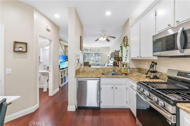 28305 Paseo El Siena Unit 10, Laguna Niguel, CA 92677 - kitchen with appliances with stainless steel finishes, a ceiling fan, dark wood-style flooring, white cabinetry, and light stone countertops